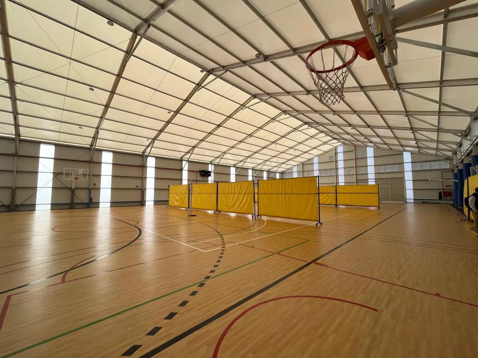 Interior de pabellón deportivo cubierto con pista de baloncesto