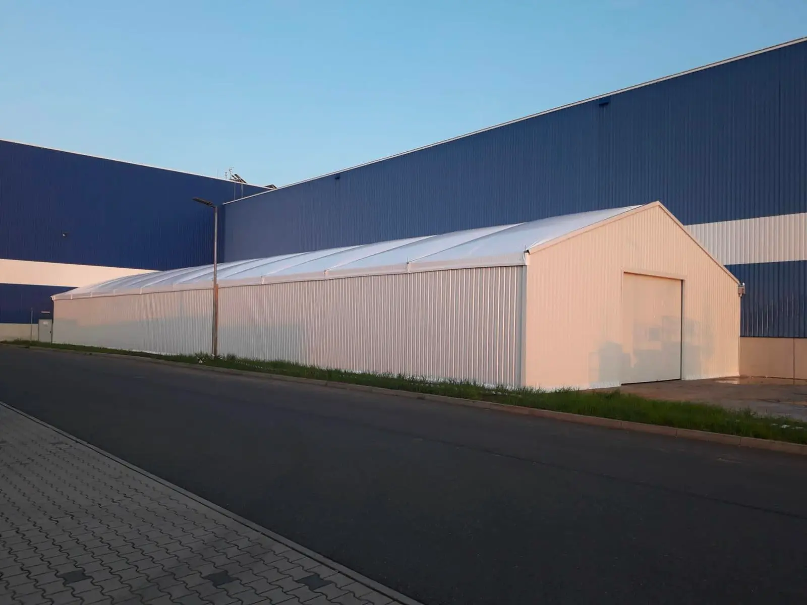 Nave industrial desmontable con puerta roja para almacenaje y logística en Zaragoza